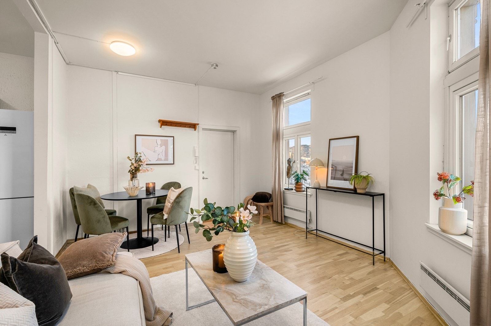 Her får du en lys og trivelig åpen stue på 18,5m² med god plass til både sofa og spiseplass Galleribilde