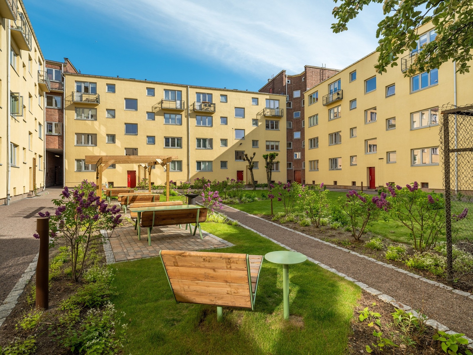 Siden vi er så godt i gang, ser vi nærmere på det siste bakgårdsrommet. Det er også to felles solstoler støpt i bakken og store gressplener med omkringliggende beplantning. Galleribilde