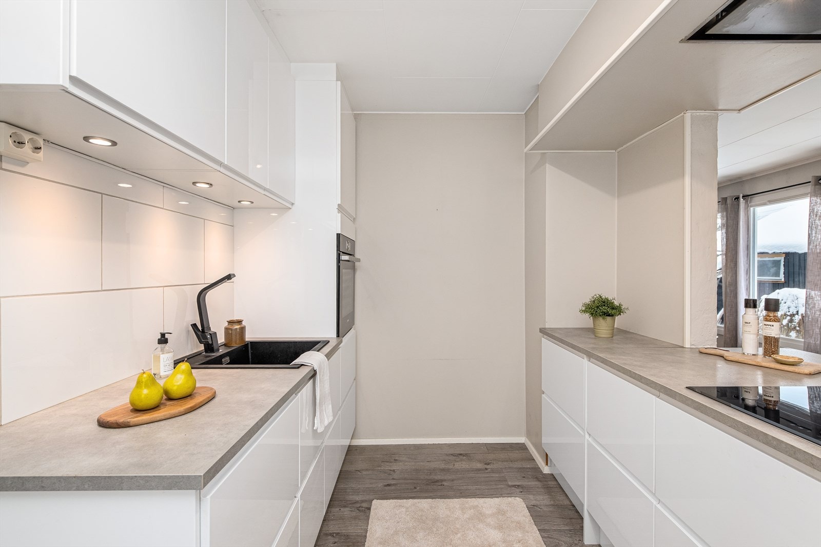 Kjøkkeninnredningen har slette fronter og en solid laminat benkeplate. Galleribilde