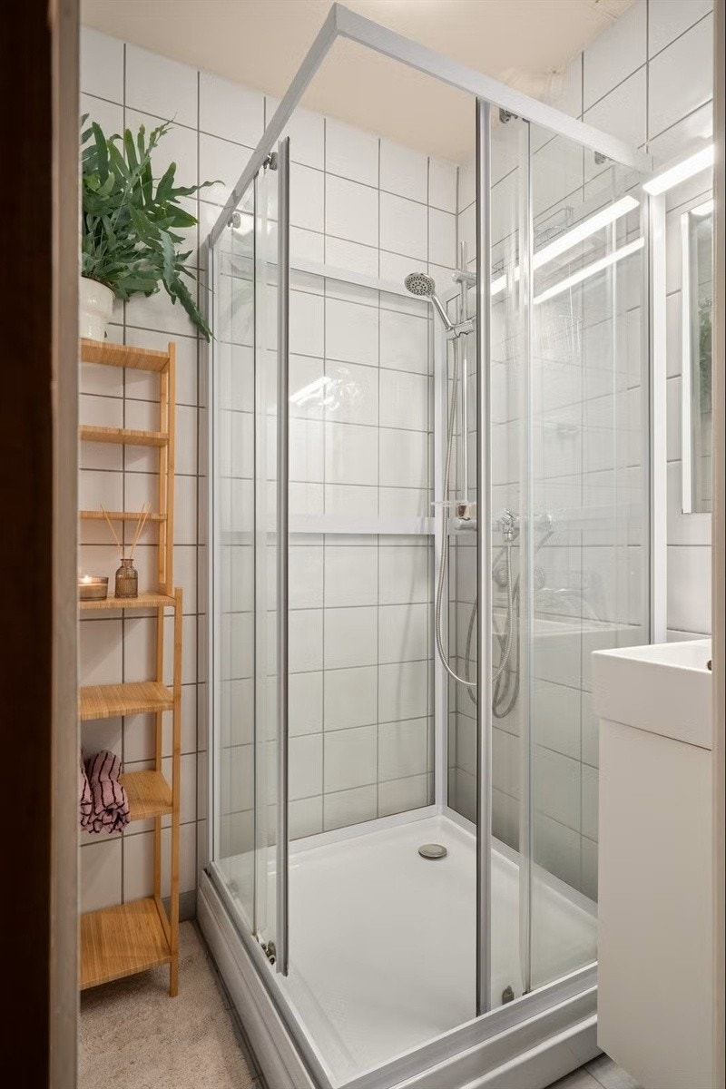 Bad med dusjkabinett og baderomsskap med servant Galleribilde