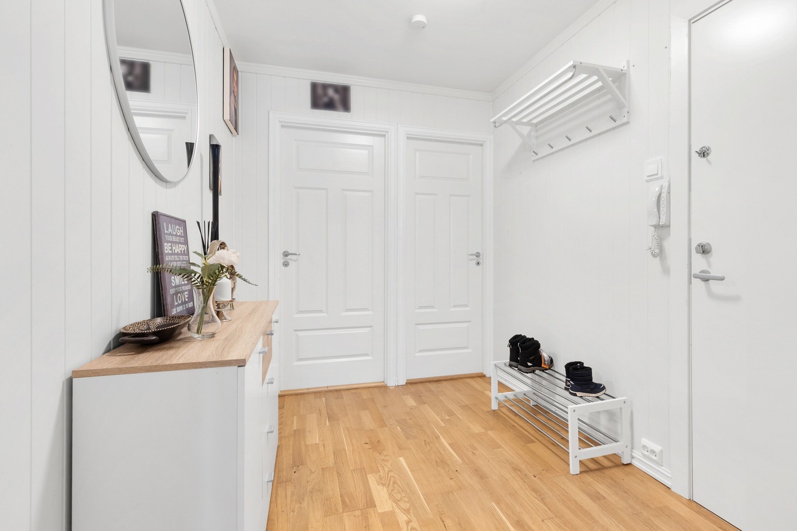 Romslig entré med 3-stavs parkett på gulv, panel på vegger og slett flate i himling Galleribilde