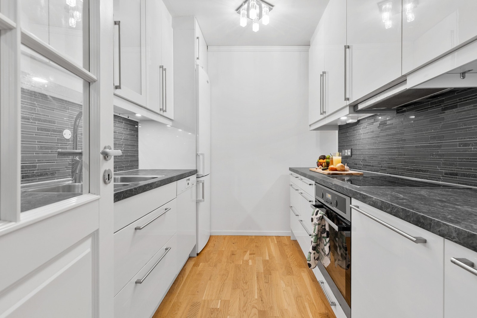 Kjøkkeninnredning fra 2015 med glatte fronter og laminat benkeplate Galleribilde