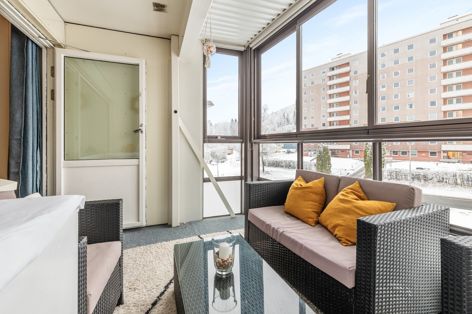 Balkongen har teppe på gulv og skyvbare glassfelter Galleribilde