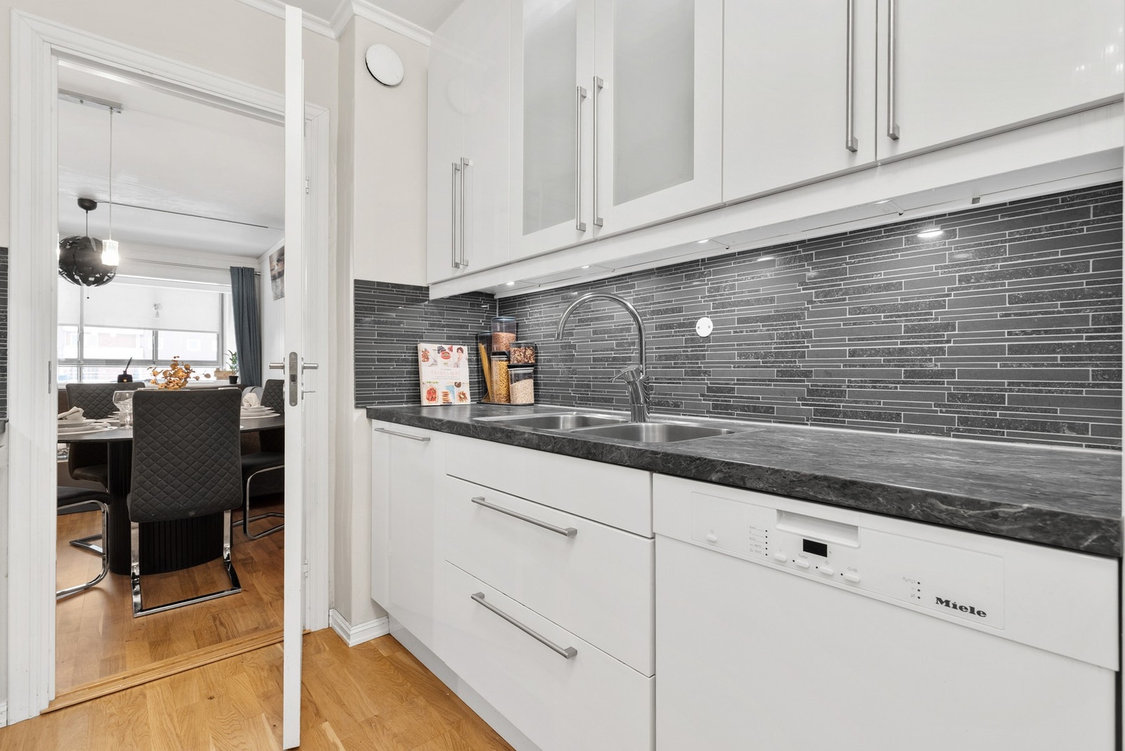 Videre har innredningen oppvaskmaskin og nisje for kjøl/fryseskap Galleribilde