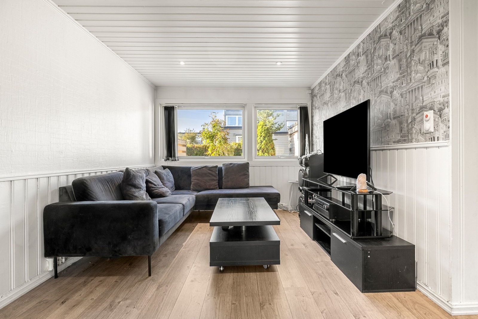 En koselig sofakrok med store vinduer som slipper inn rikelig med dagslys. Galleribilde