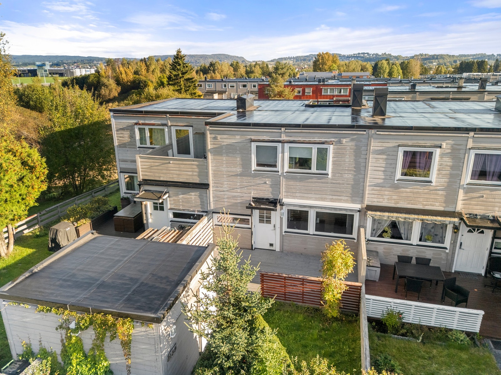 Inngangspartiet fremstår lunt og skjermet med hage og terrasse. Galleribilde