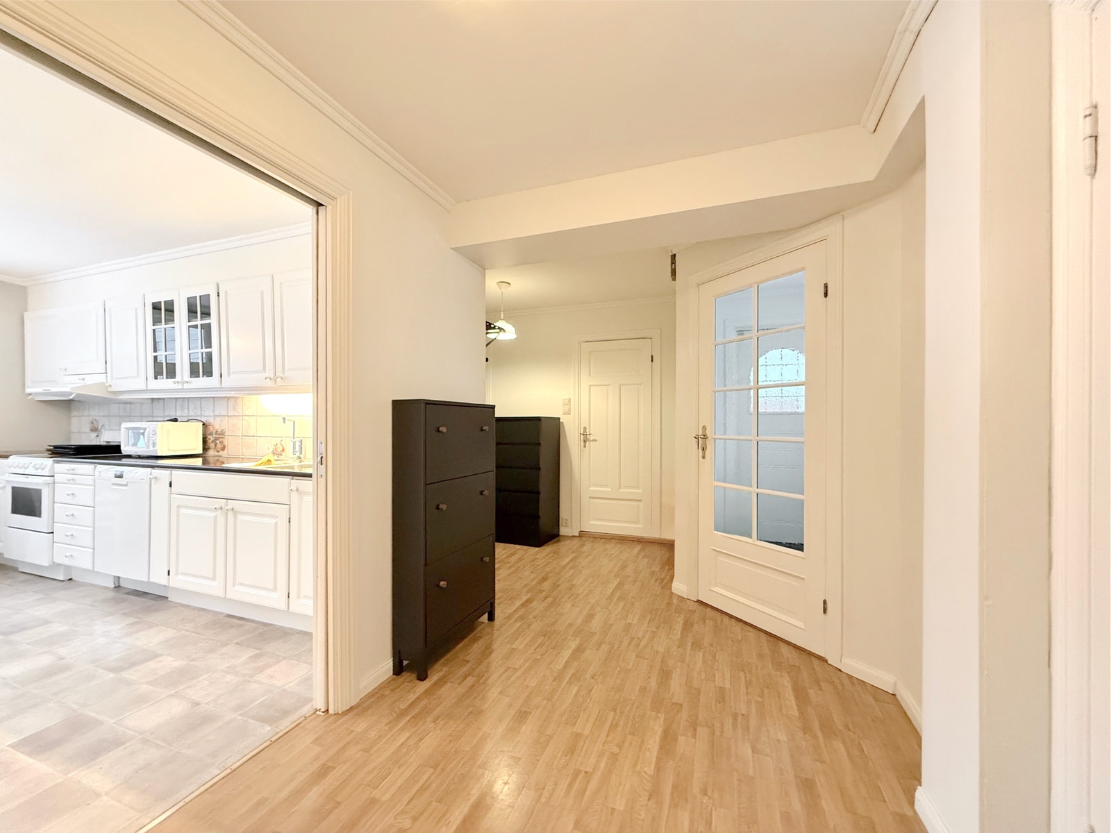 Lys mellomgang binder sammen stue, kjøkken og soverom, med oppbevaringsmulighet Galleribilde