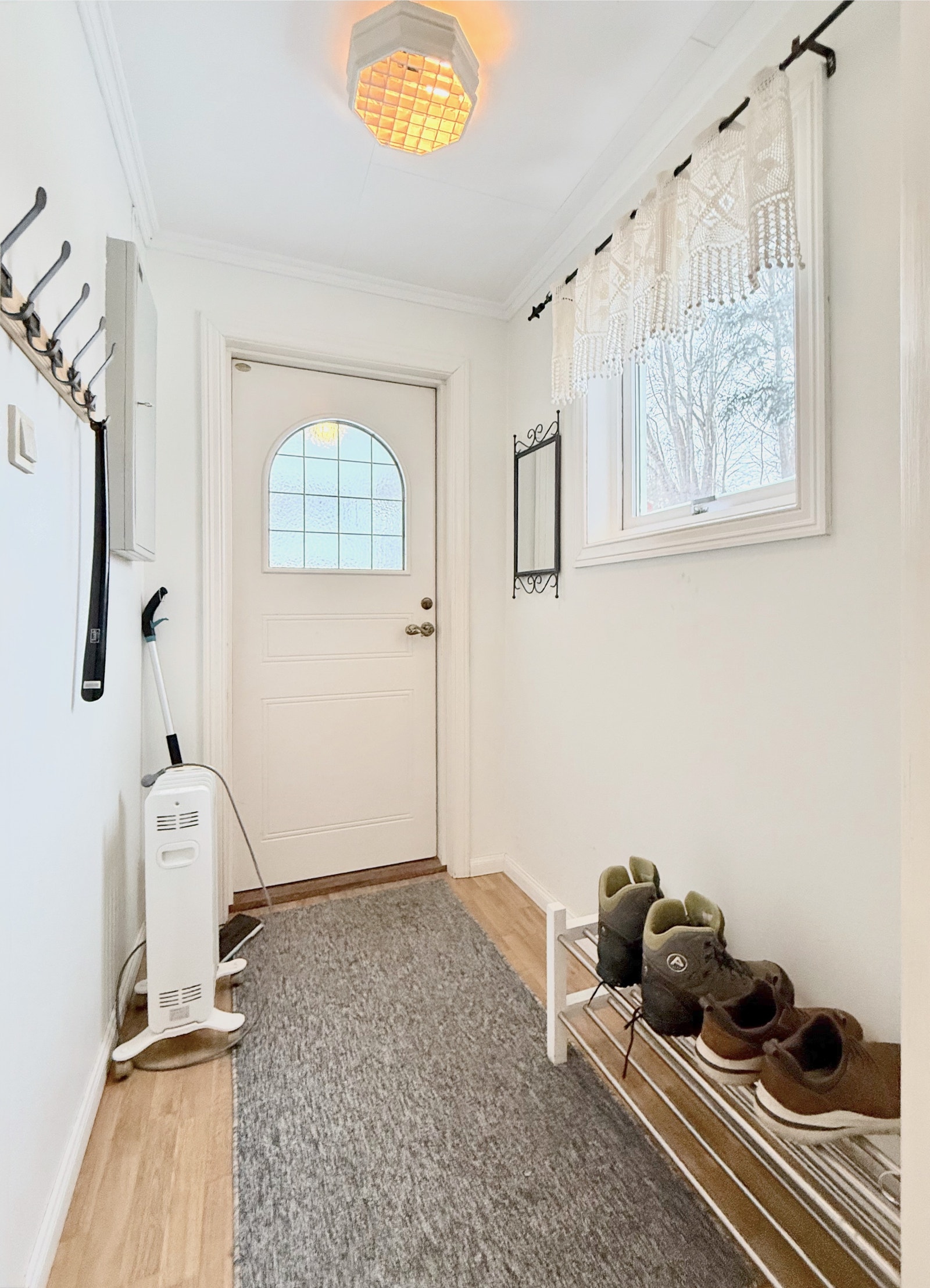 Lys entré med ytterdør, vindu og plass til sko og yttertøy Galleribilde