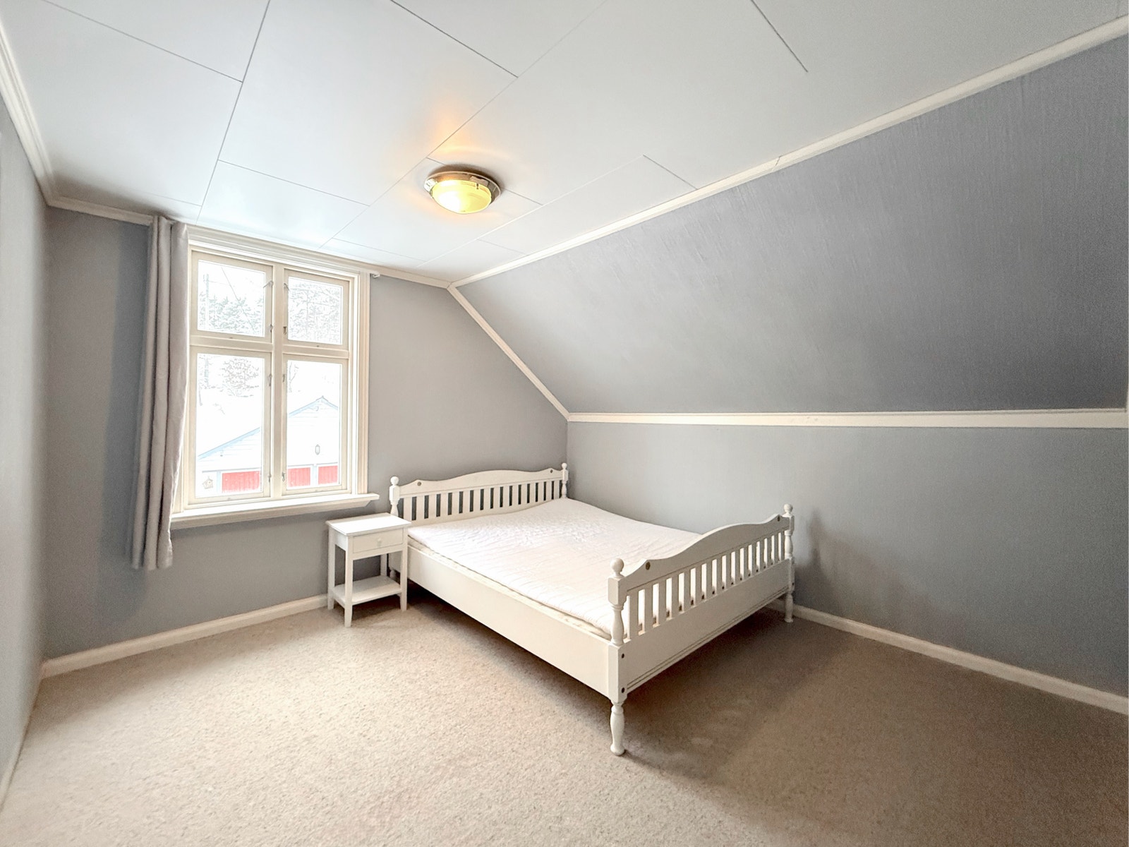 Soverom på loftet med skråtak, teppebelagt gulv og plass til dobbeltseng Galleribilde