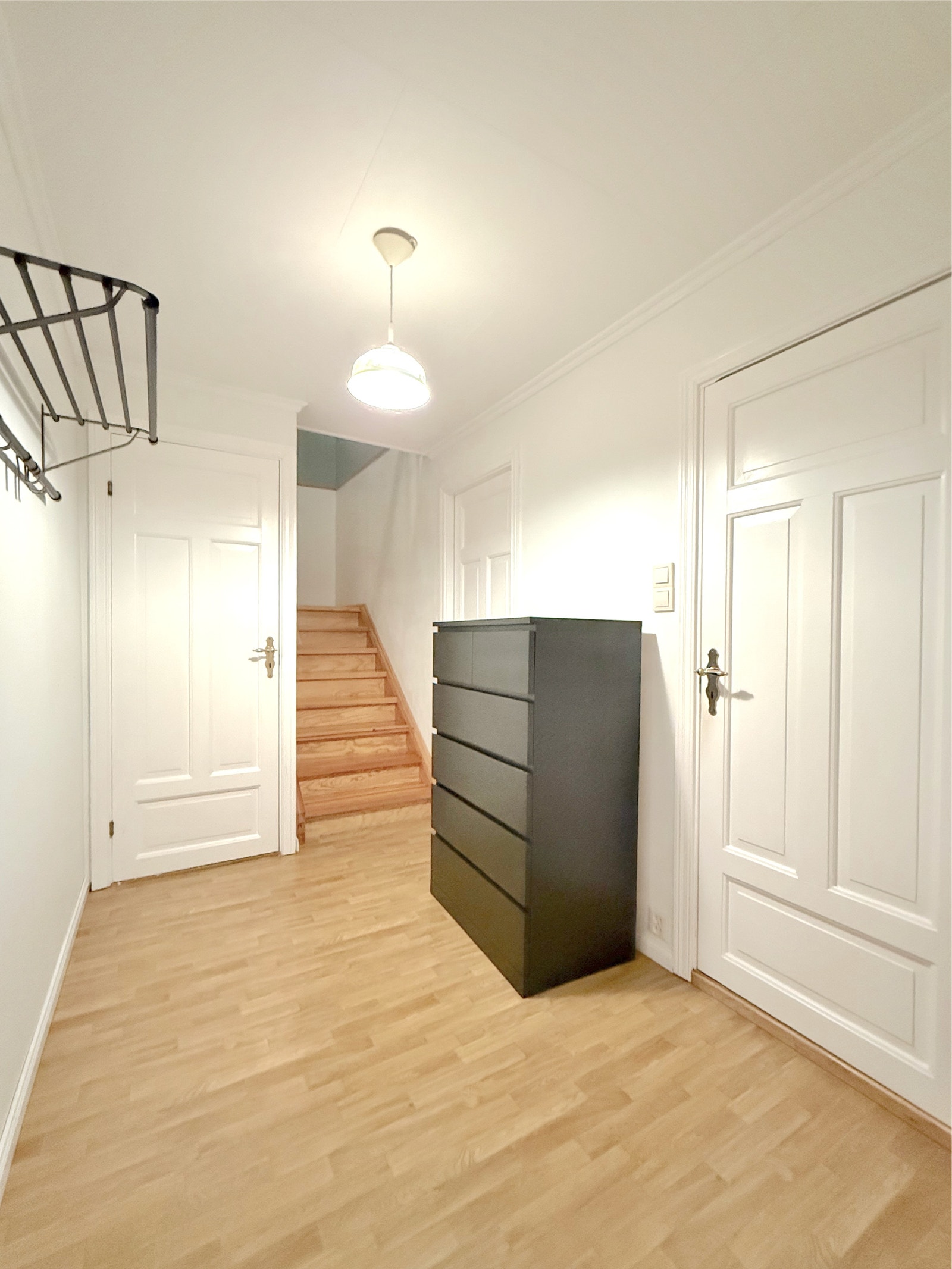 Gang med trapp til loftsetasjen og praktisk knaggrekke og kommode Galleribilde
