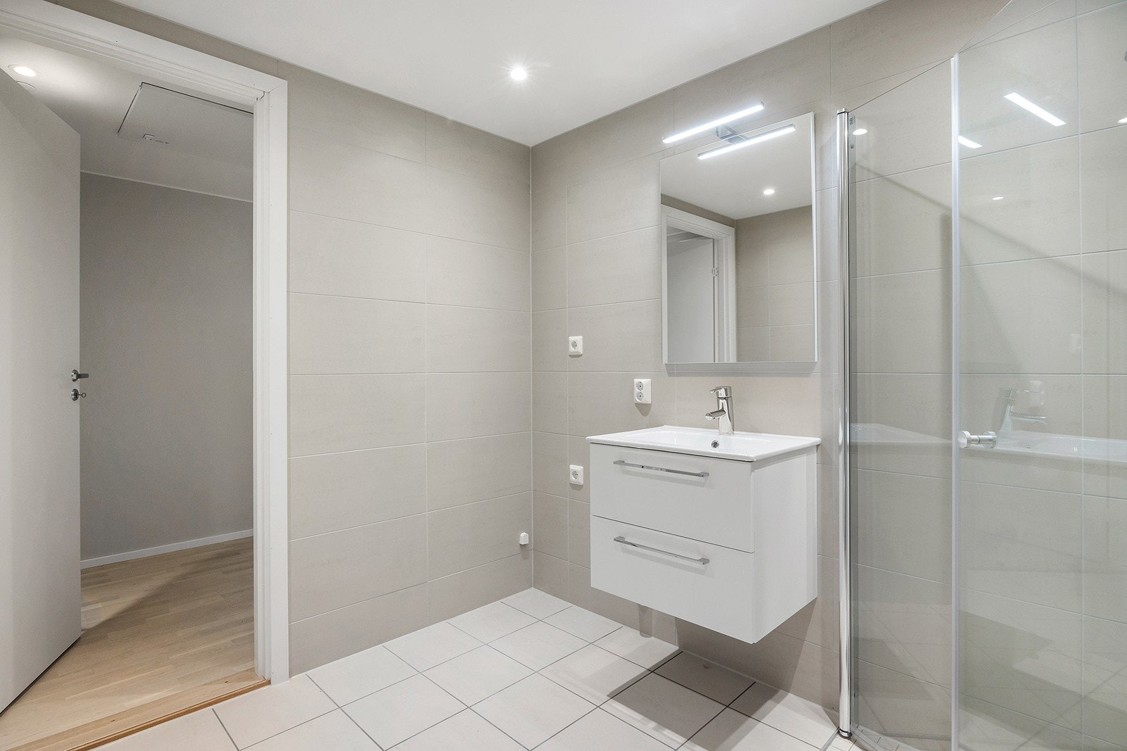 Lyst og flott bad i sandfargede toner med vannbåren gulvvarme. Galleribilde