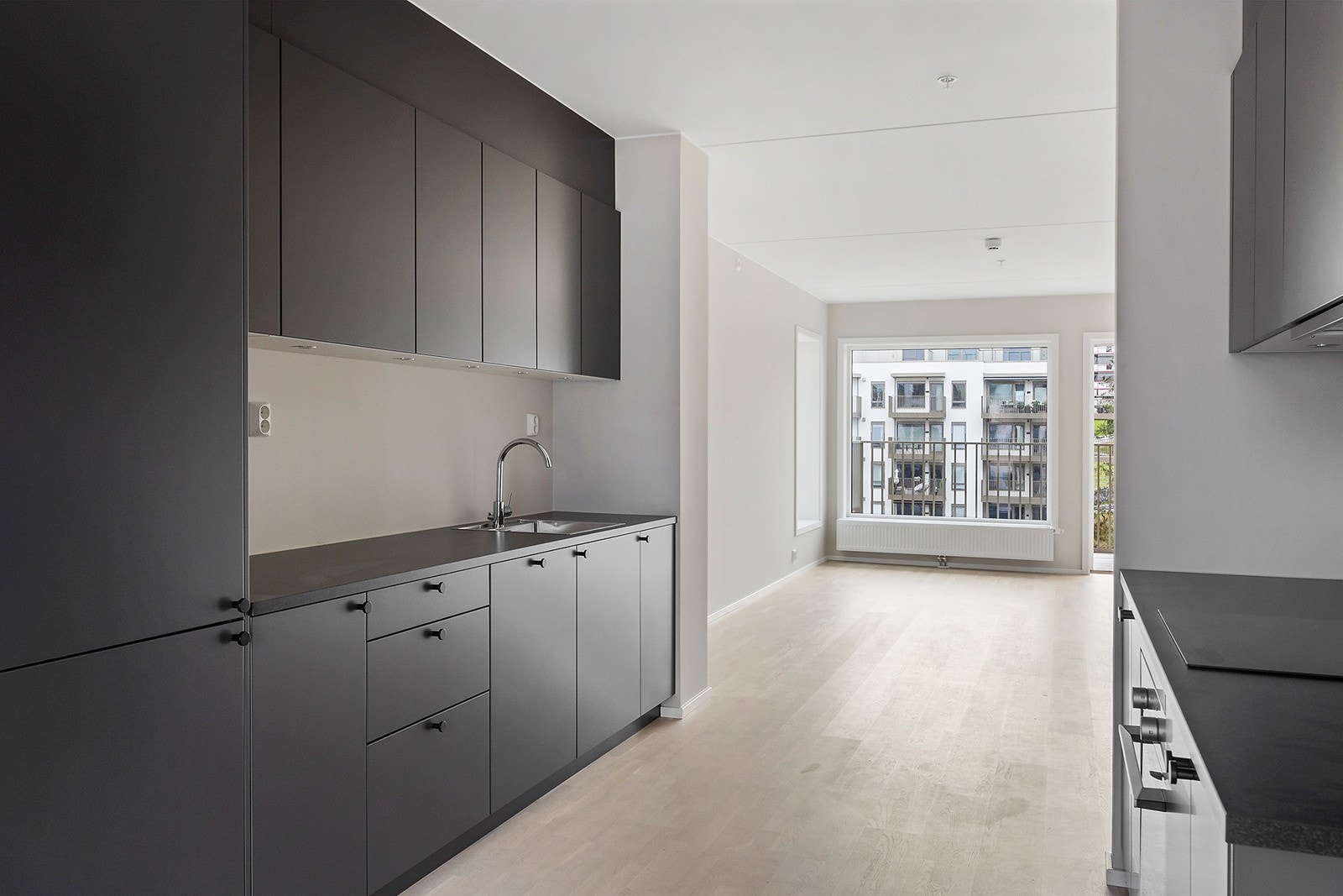 Moderne og tidløst fargevalg på kjøkken med behagelig downlights ned på kjøkkenbenken. Galleribilde