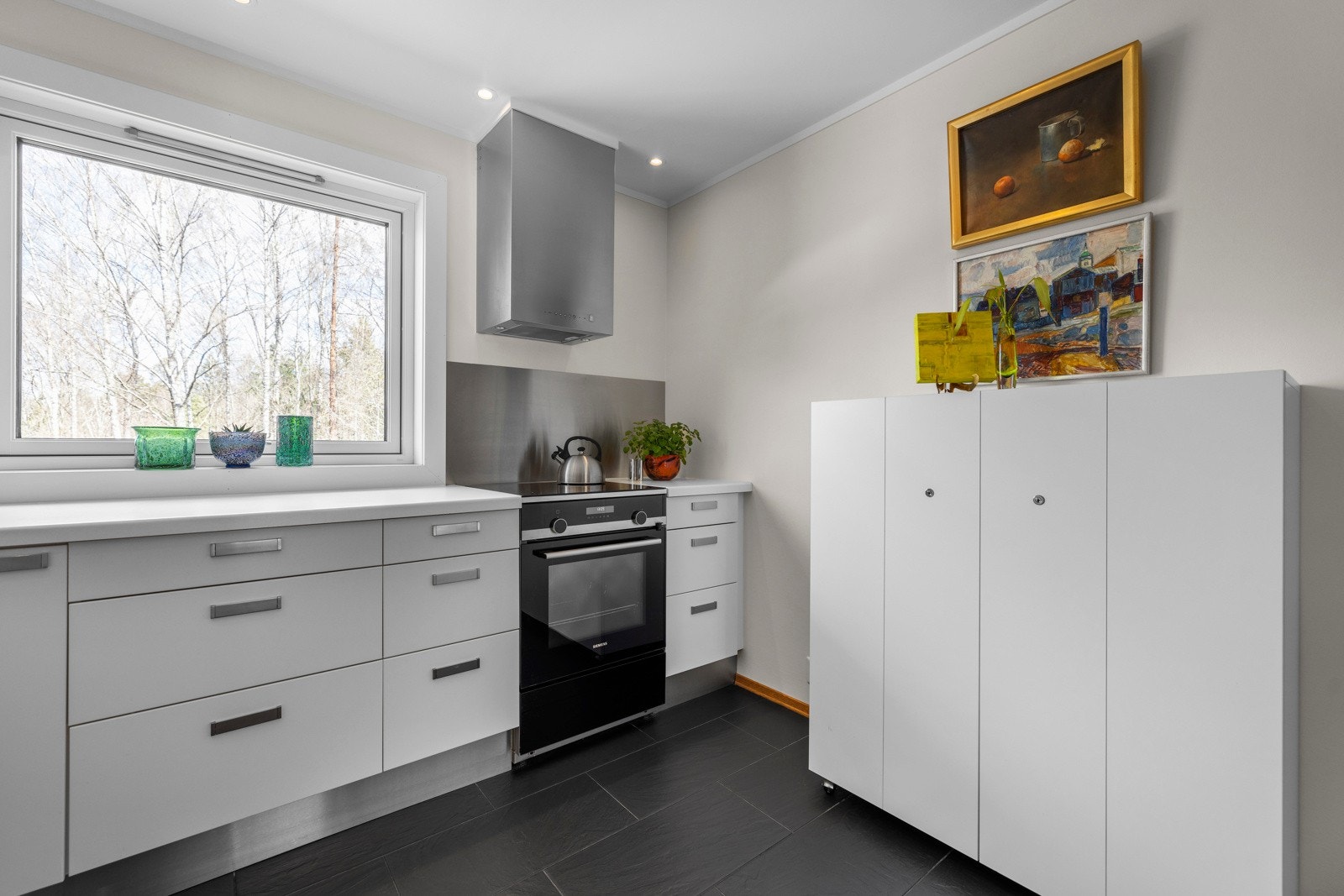 Benkeplaten av laminat og slette fronter på skapene fra 2007 gir et rent og pent utseende Galleribilde