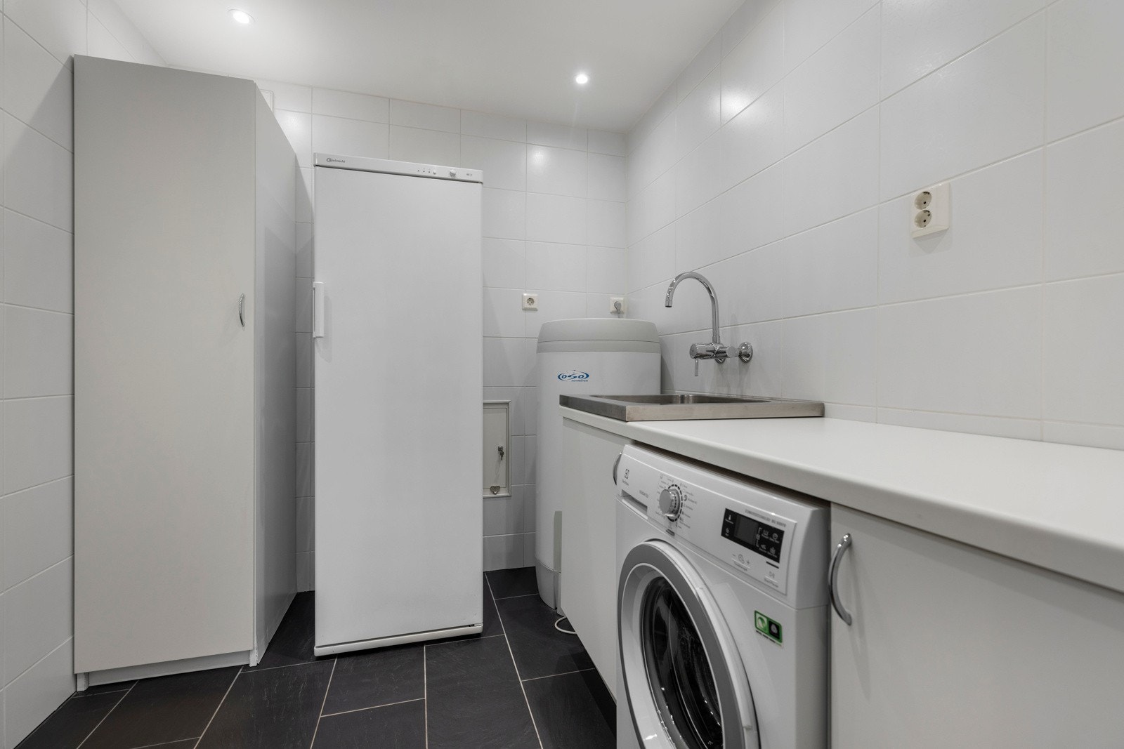 Boligen har et eget vaskerom med opplegg for vaskemaskin og utslagsvask Galleribilde