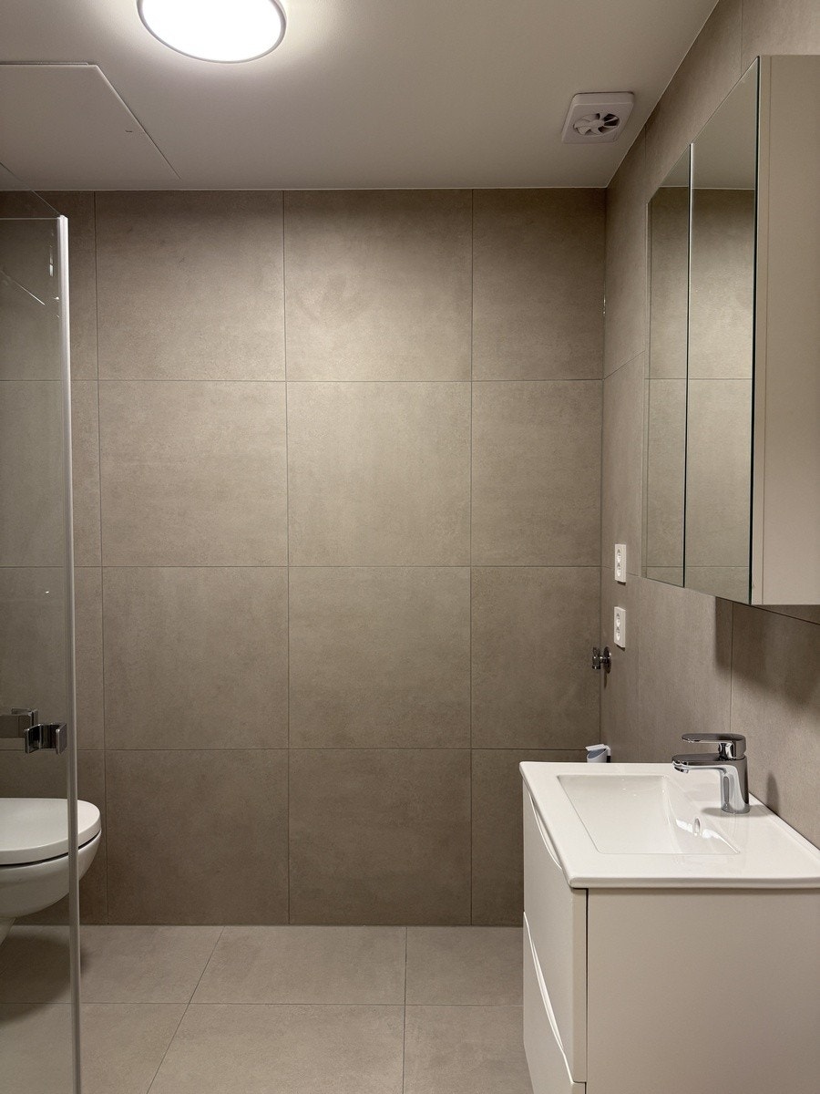 fliselagt bad med varmekabler og opplegg for vaskemaskin Galleribilde