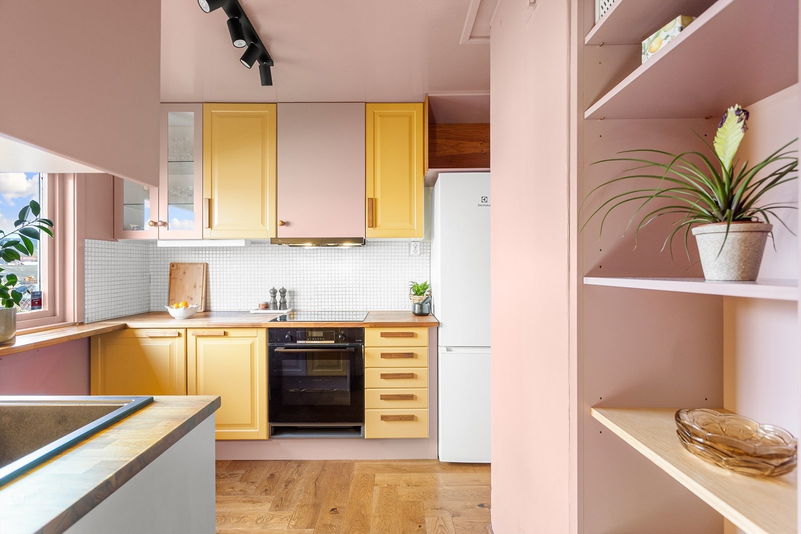 Du møter dette hyggelige kjøkkenet med malte fronter med hvite mosaikkfliser på veggen. Galleribilde