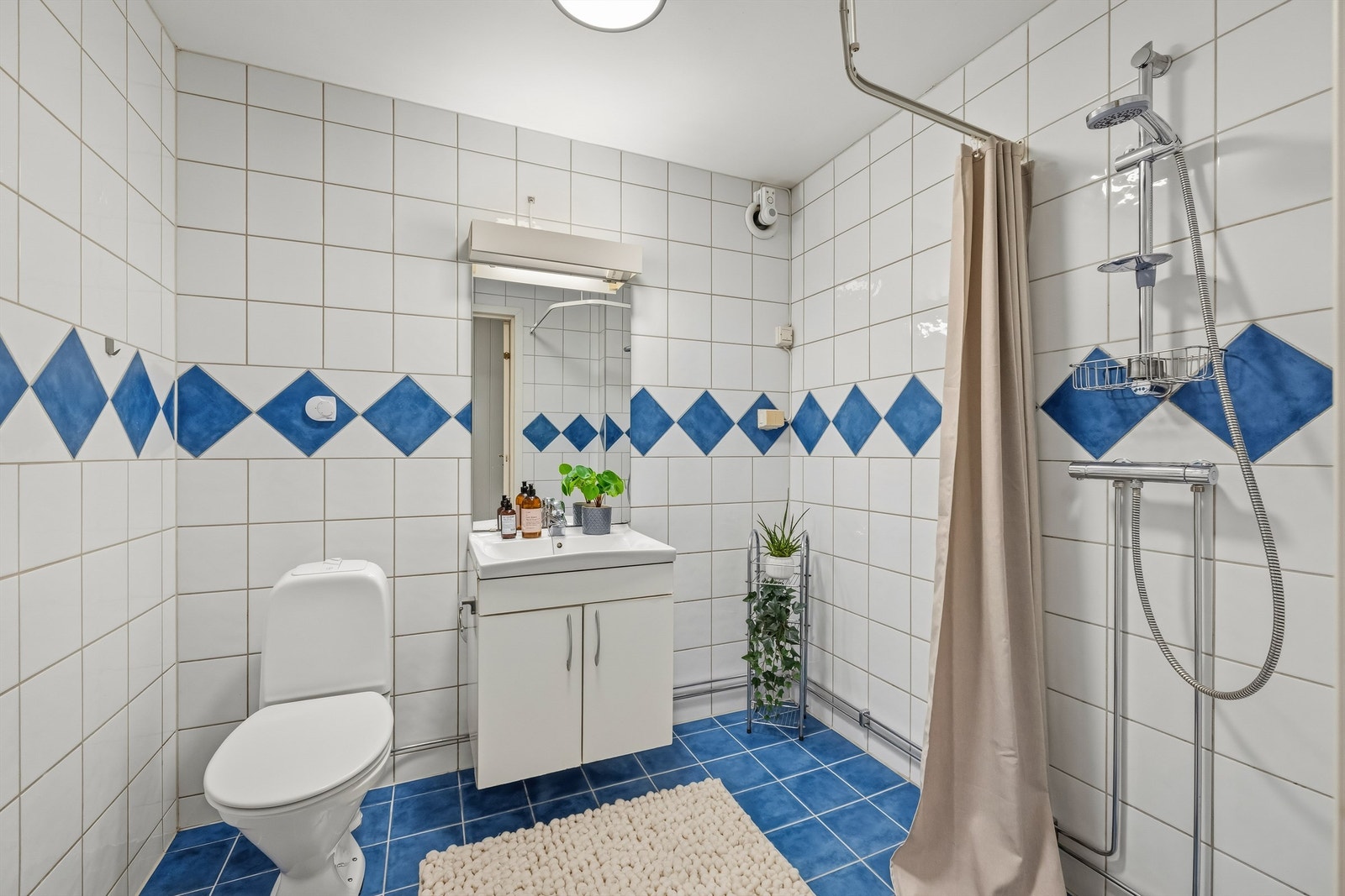 Badet i underetasjen har flislagte overflater, varme i gulv og opplegg for vaskemaskin. Galleribilde