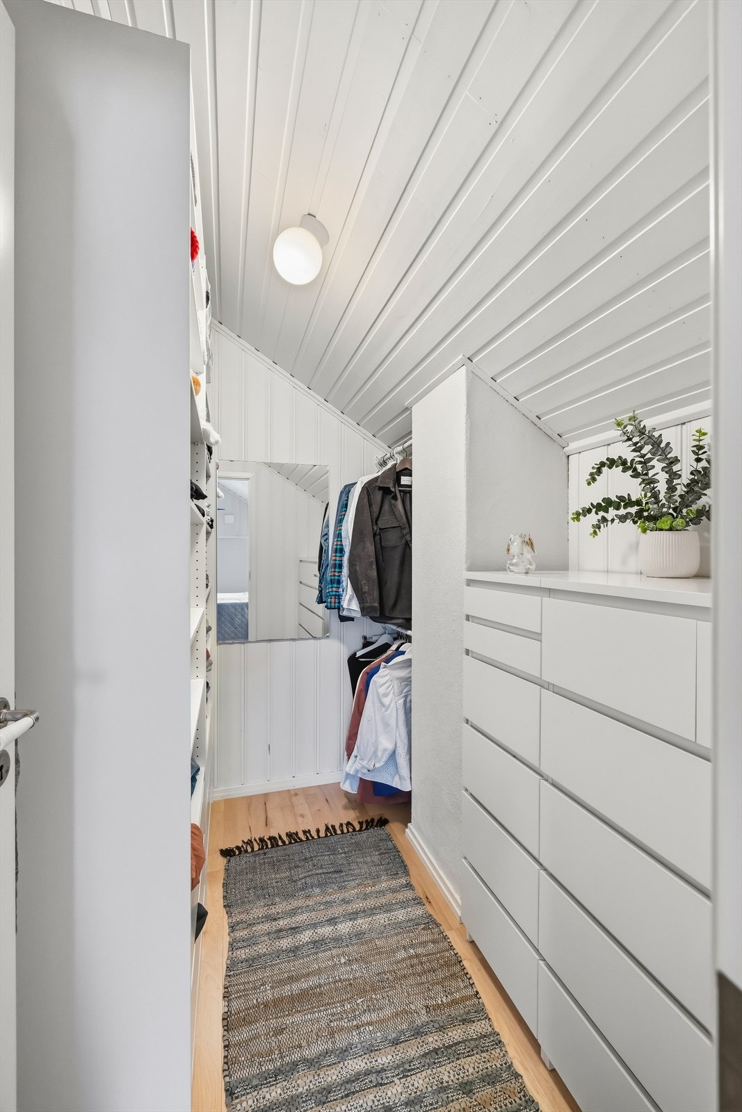 Omkledningsrommet i loftsetasjen har praktiske garderobeskap og hylleløsninger for optimal orden. Galleribilde