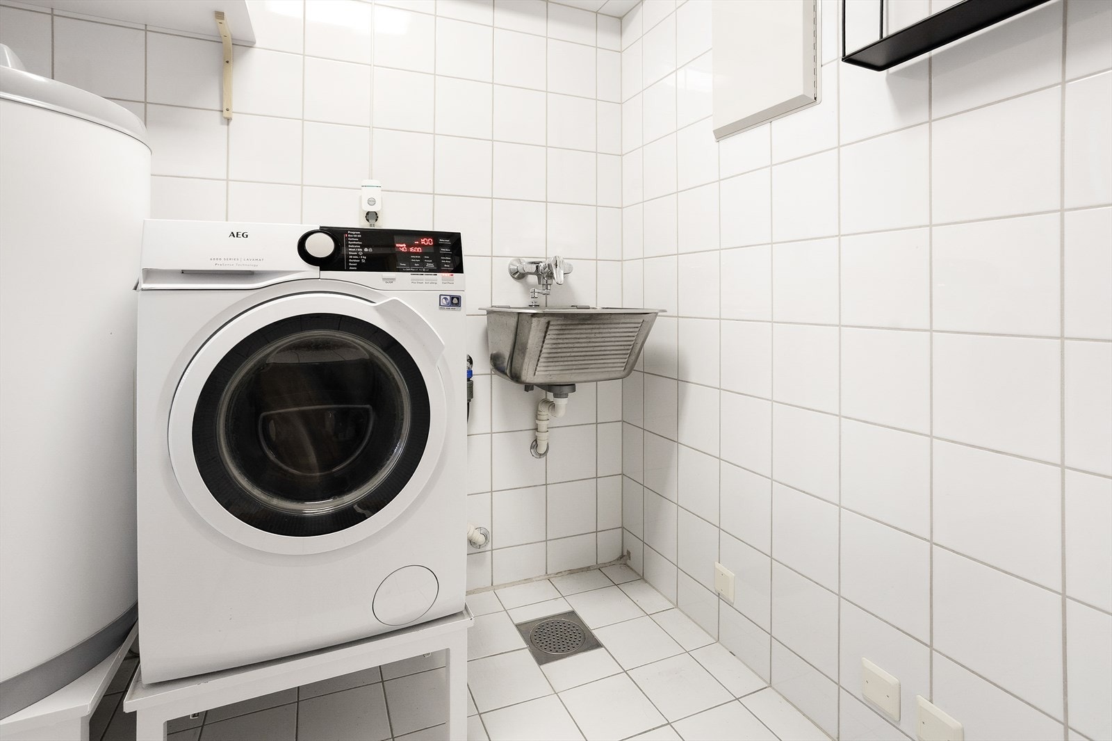 Leiligheten har et praktisk og funksjonelt vaskerom med utslagsvask og opplegg for vaskemaskin. Rommet er utstyrt med fliser på vegger, malte plater i taket og flislagt gulv med varmekabler. Galleribilde