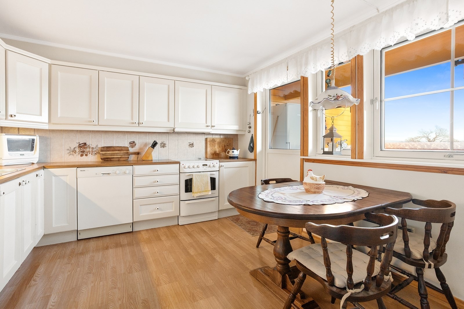 Kjøkkenet har en praktisk og funksjonell innredning montert i L-form, med slette fronter og laminat benkeplate som gir et tidløst og lettstelt uttrykk. Galleribilde