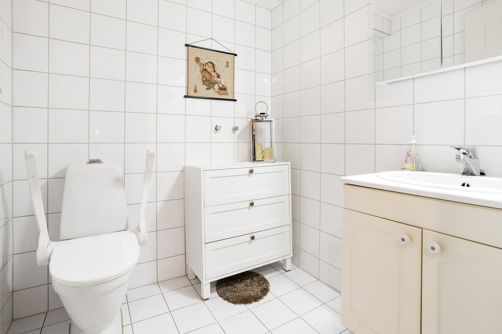 Bad med Innredning bestående av nedfelt servant og toalett. Det er lagt opp for montering av dusjhjørne eller dusjkabinett. Veggene er flislagt, og taket har malte plater. Gulvet er flislagt og utstyrt med varmekabler. Badet er bygemeldt som bod. Galleribilde