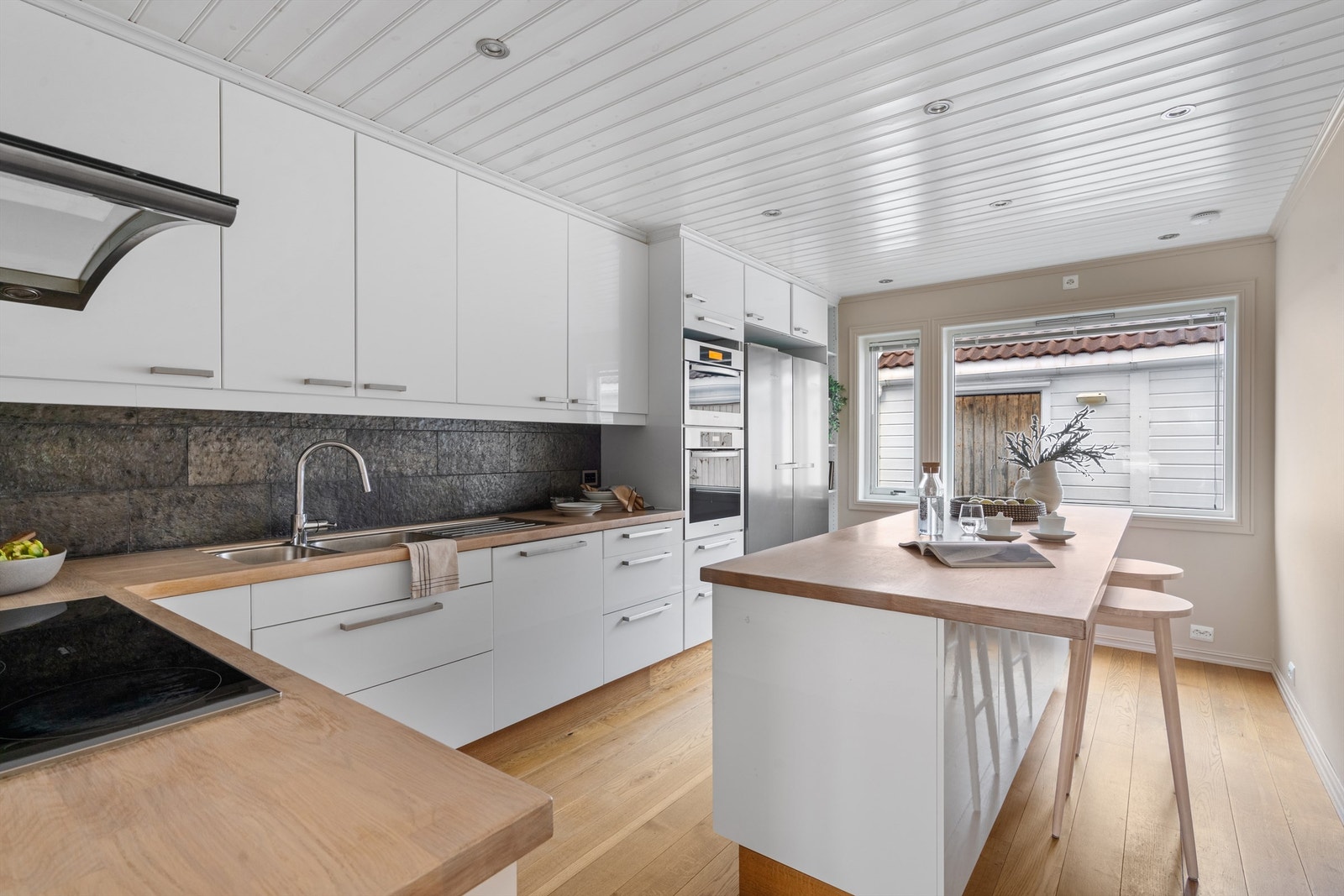 Romslig kjøkken med spiseplass.
Kjøkkeninnredningen fra IKEA ( 2012), i tidløs hvit og benkeplate av tre Galleribilde