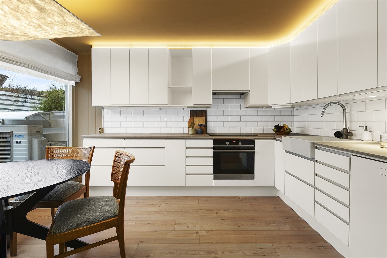 Delikat og tidløst kjøkken med hvite, slette fronter og laminert benkeplate Galleribilde