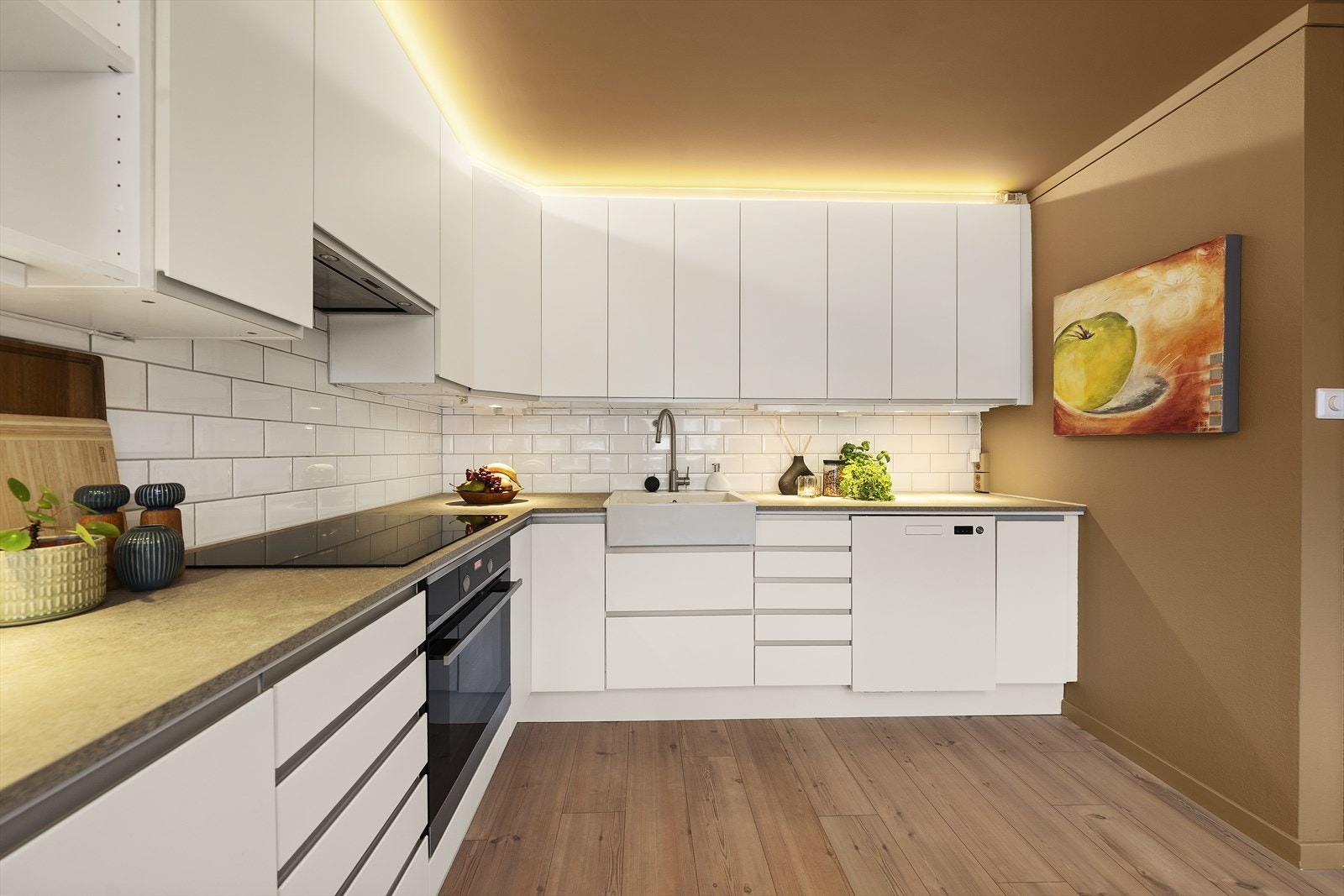 Kjøkkeninnredningen er godt tilpasset rommets utforming og tilbyr godt med skap- og benkeplass Galleribilde