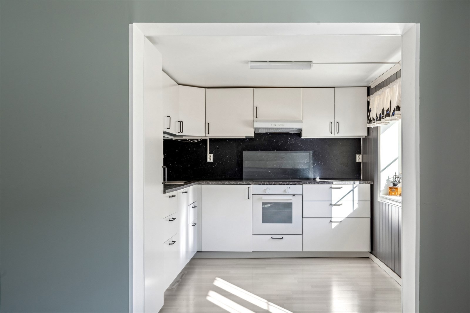 Kjøkkenet er ca 8,4 m² og har innredning med folierte skrog med slette fronter og laminert benkeplate. Galleribilde