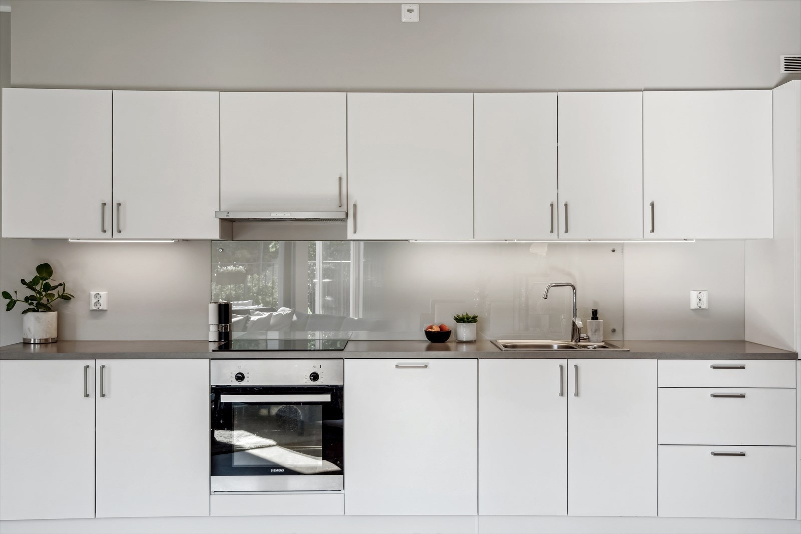 Kjøkkenet er innredet med HTH kjøkkeninnredning med slette fronter. Benkeplaten er i laminat og har nedfelt stålvask. Kjøkkenet er utstyrt med integrert stekeovn, steketopp, oppvaskmaskin samt kjøleskap/frys. Galleribilde