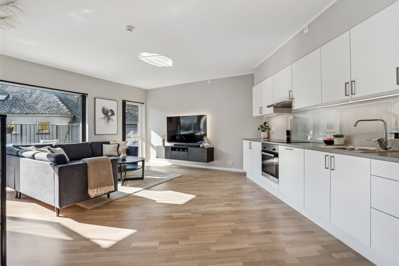 Stuen er luftig og har en åpen løsning mot kjøkkenet, noe som skaper en sosial og hyggelig atmosfære Galleribilde