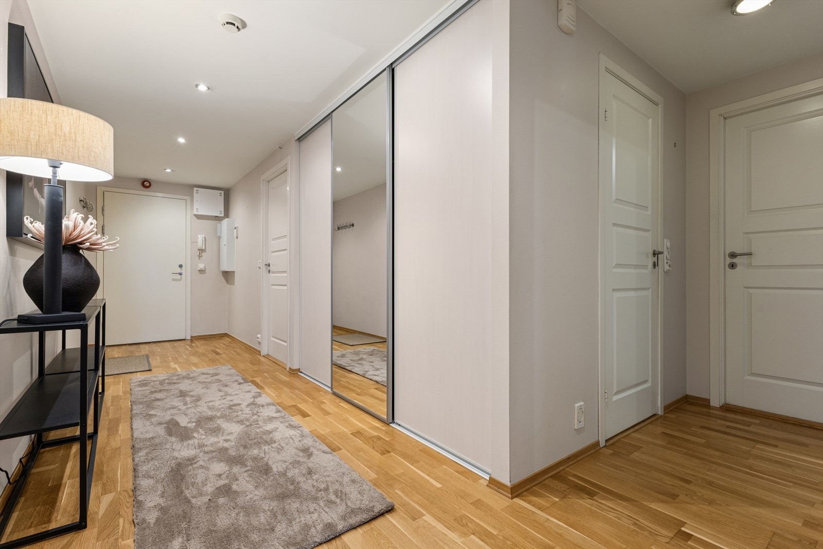 Romslig gang med praktisk skyvedørsgarderobe. Callinganlegg er montert ved inngangsdøren. Galleribilde