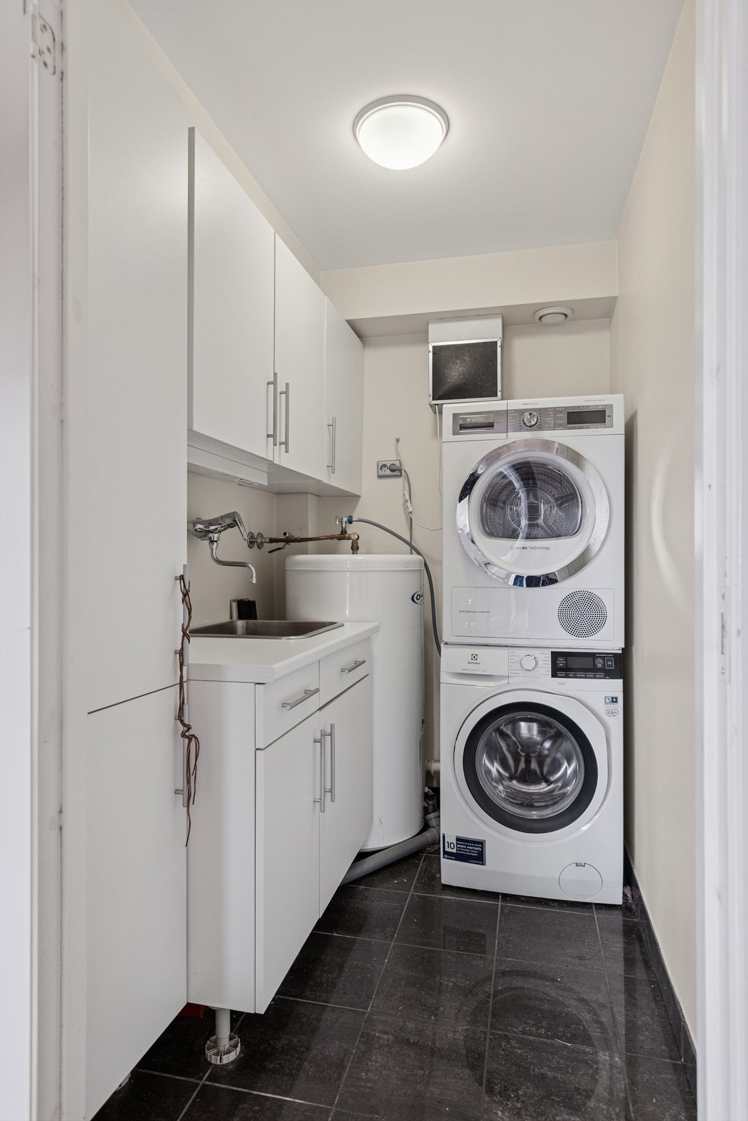 Stort og praktisk vaskerom med god oppbevaringsplass. Varmtvannstank på ca 200 liter. Galleribilde