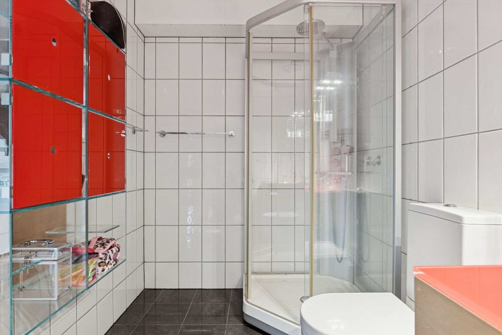 Pent flisbelagt bad, innredet med dusjkabinett, gulvstående toalett, servant med moderne innredning og god oppbevaringsplass. Friske fargeinnslag og praktiske løsninger gir et lyst og funksjonelt rom. Galleribilde