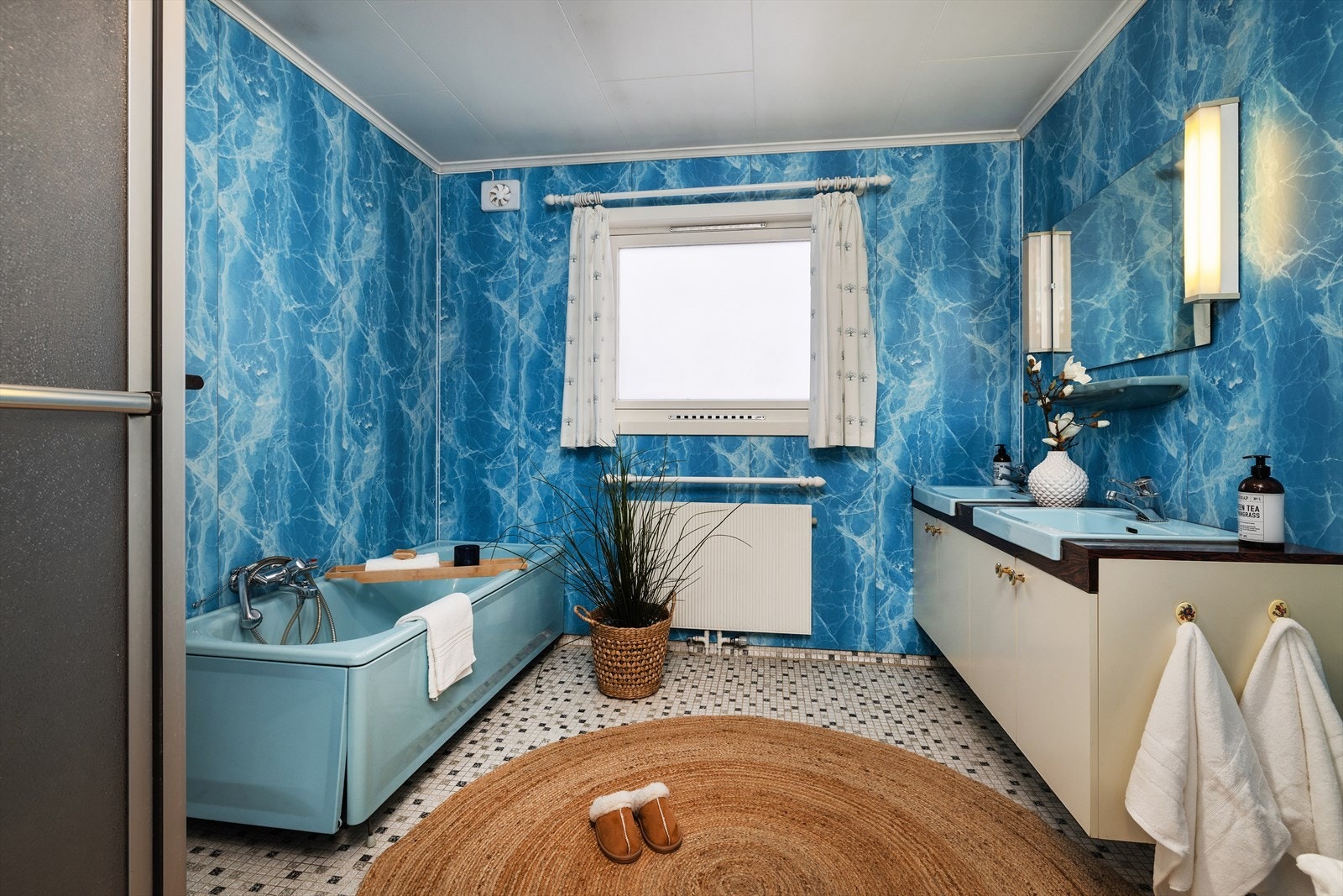 Badet er fra byggeåret, med en baderomsinnredning som har heldekkende servant med to vasker. Galleribilde