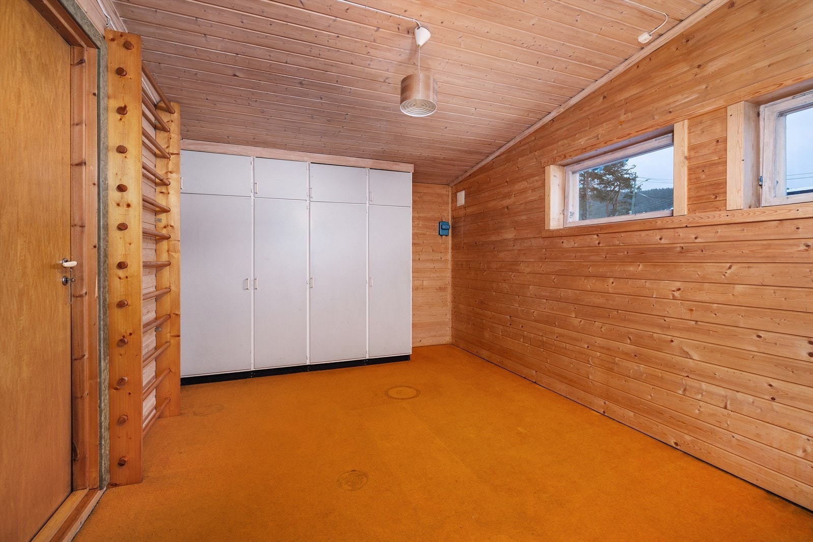 Et disponibelt rom med garderobeskap og ribbevegg, egnet som trimrom eller hobbyrom. Galleribilde