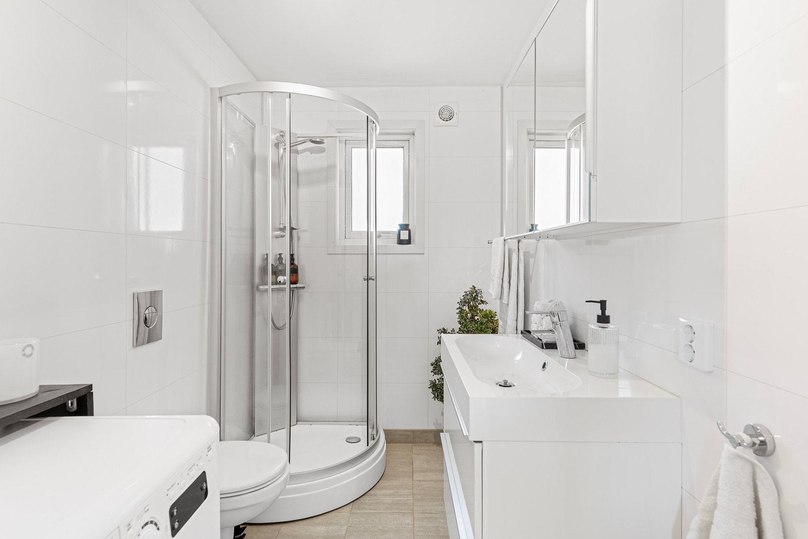 Rommet ble renovert i 2018 og har fliser på gulv med varmekabler og hvite våtromsplater på veggene med flismønster. Opplegg til vaskemaskin. Galleribilde