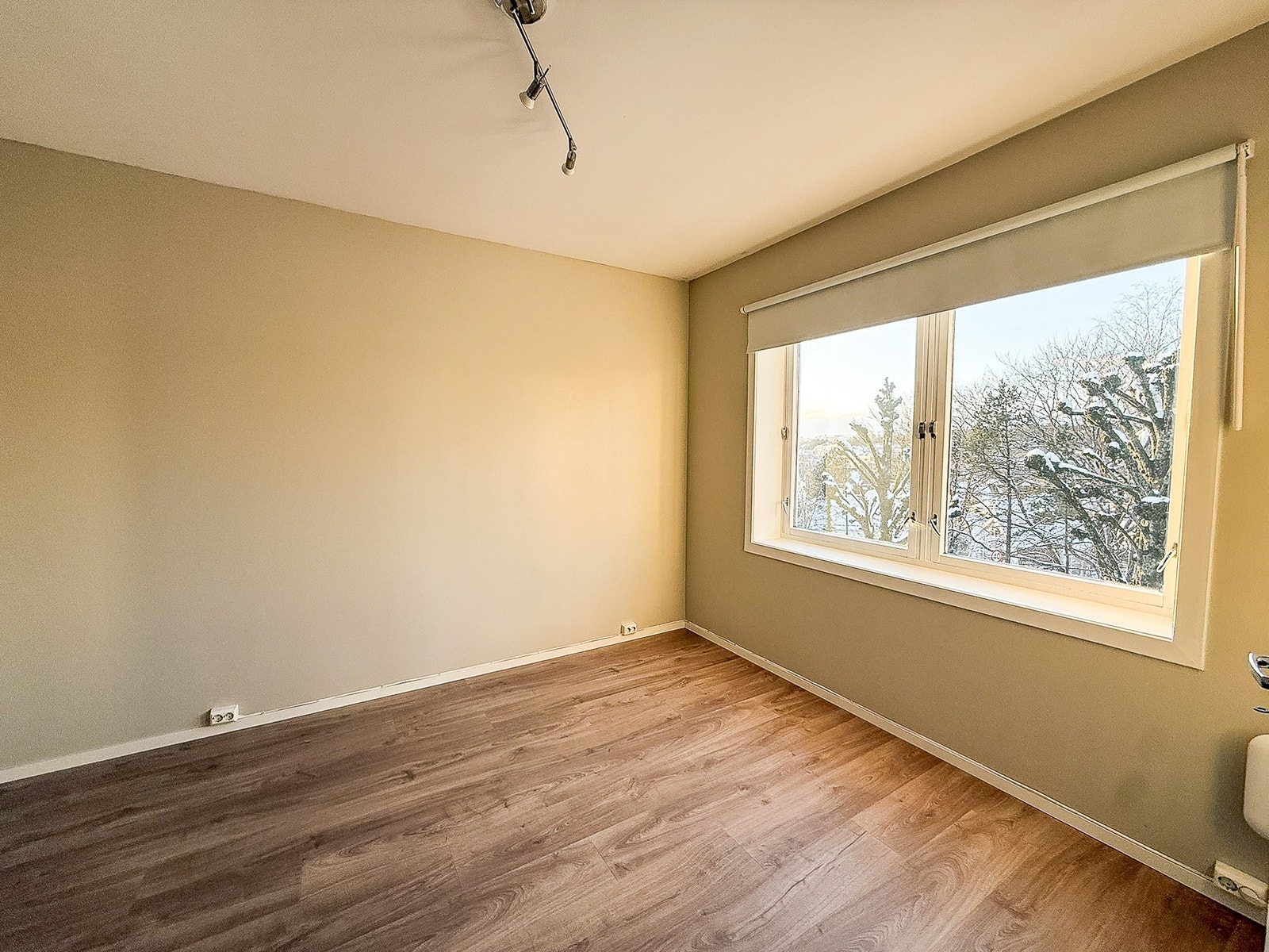 Soverommet har stort vindu som gir rikelig med naturlig lys til leiligheten Galleribilde