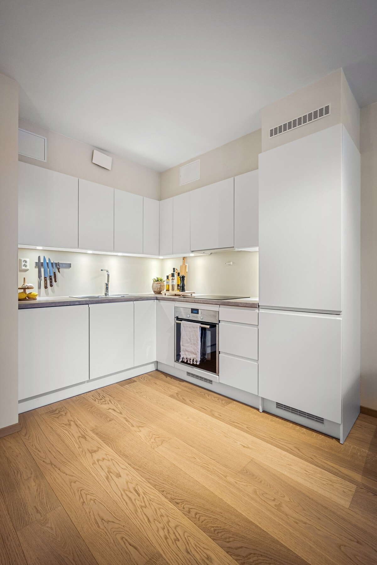 Kjøkkenet kommer med spotter under overskapene, en praktisk løsning som gjør rommet lyst og innbydende. Galleribilde