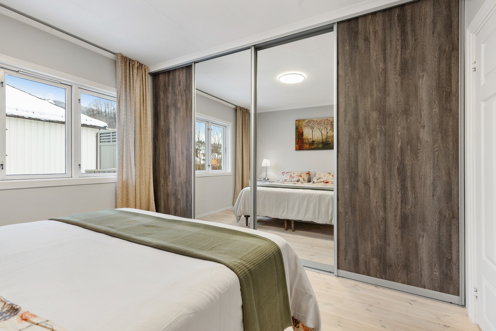 Rommet har god plass til dobbeltseng og nattbord, og det er montert en stor skyvedørsgarderobe på den ene veggen Galleribilde