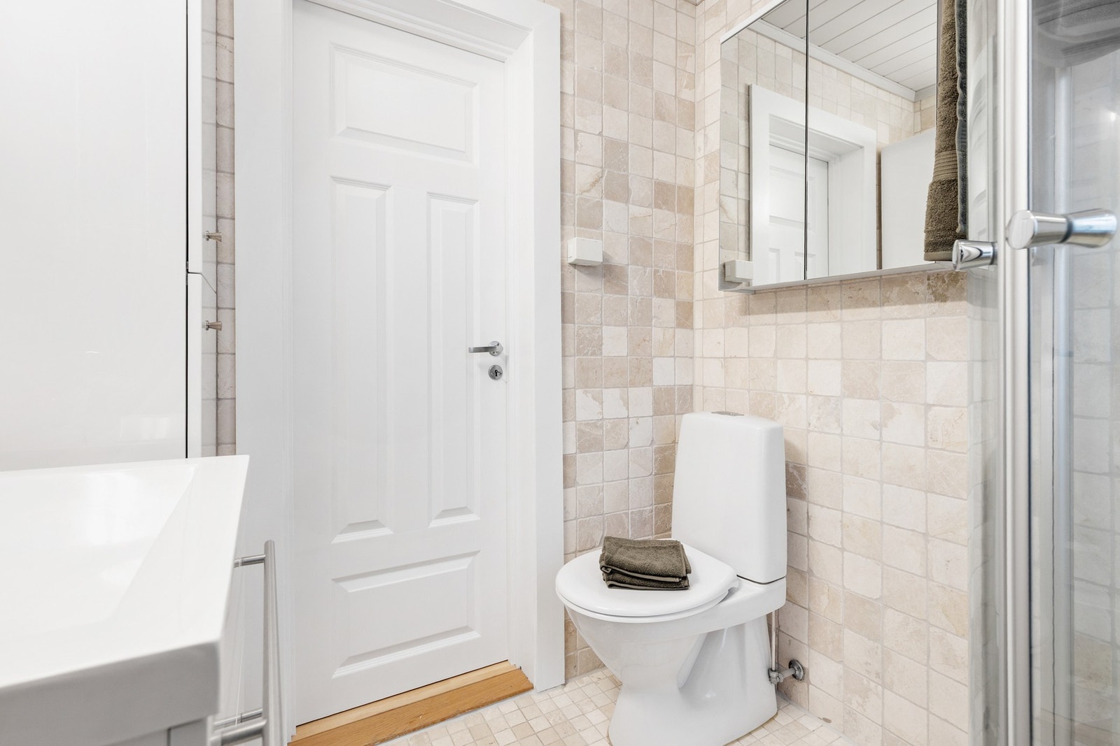 Badet er utstyrt med innredning med nedfelt servant, gulvstående toalett og dusjkabinett Galleribilde