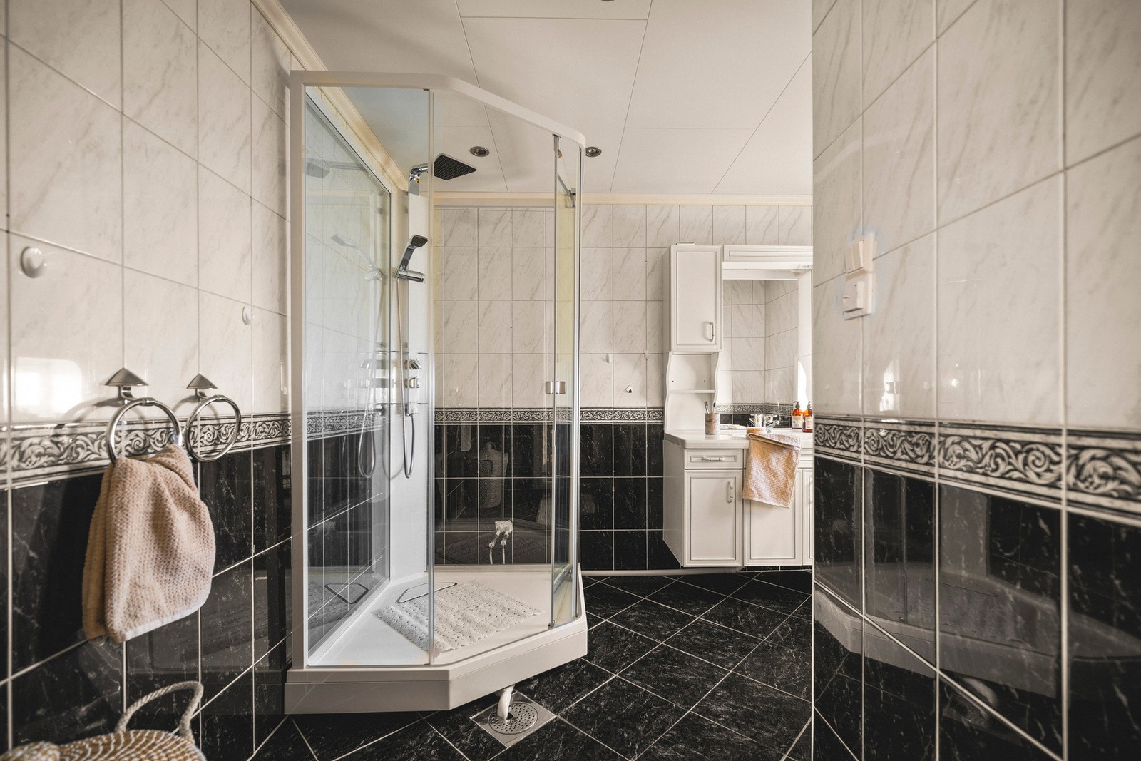 Badet inneholder toalett, helstøpt servant, skap under servant med profilerte fronter, dusjkabinett. Dusjkabinett ble satt inn i 2014. Galleribilde