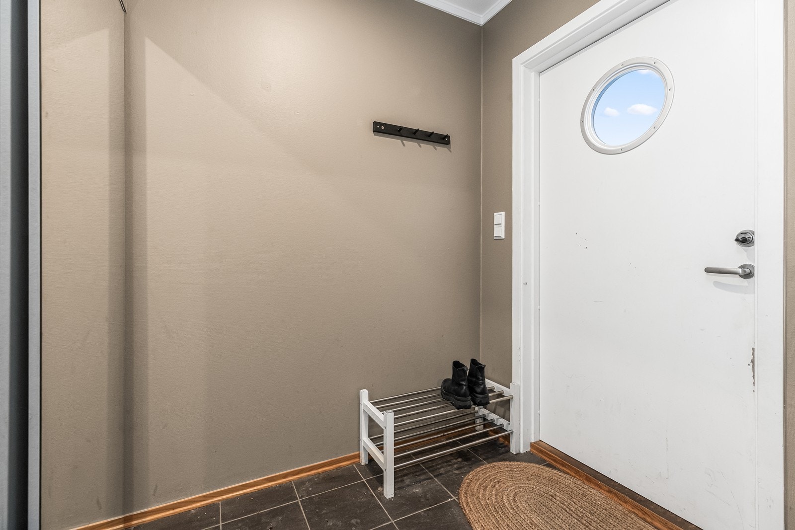 Inngangspartiet har et praktisk flislagt gulv og plass til yttertøy. Galleribilde