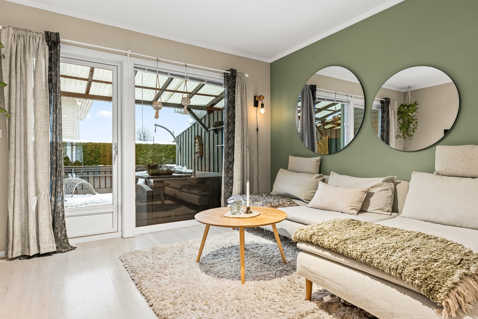 Store vindusflater og dør til terrassen gir rikelig med naturlig lys inn i stuen. Galleribilde