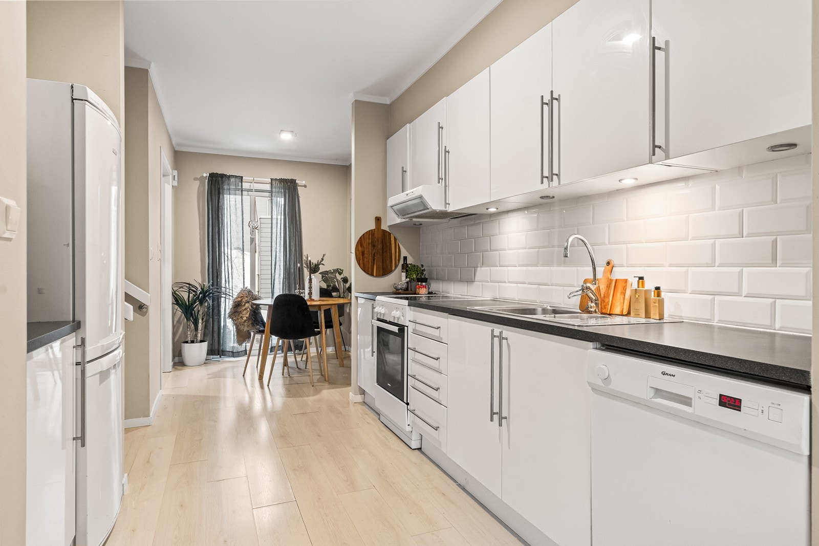 Kjøkkeninnredningen har slette fronter, laminat benkeplate og flisfelt over benken. Galleribilde