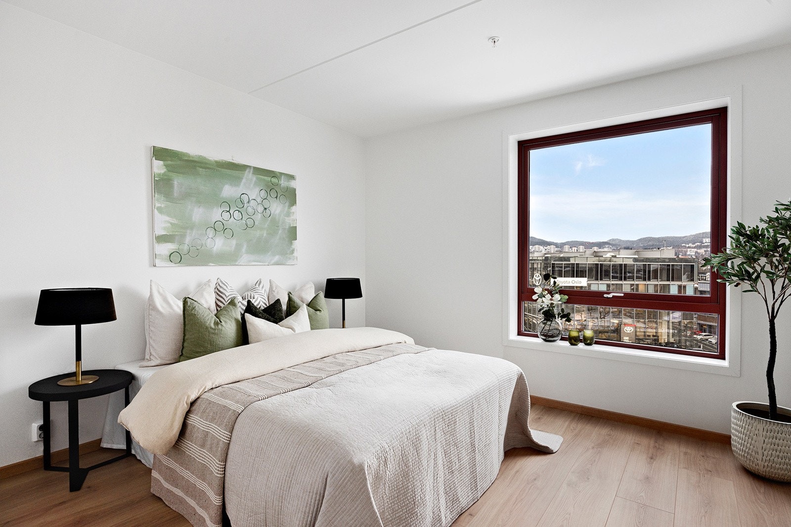 Lyst og moderne soverom med god plass til dobbeltseng, nattbord på hver side og garderobeløsning. Galleribilde