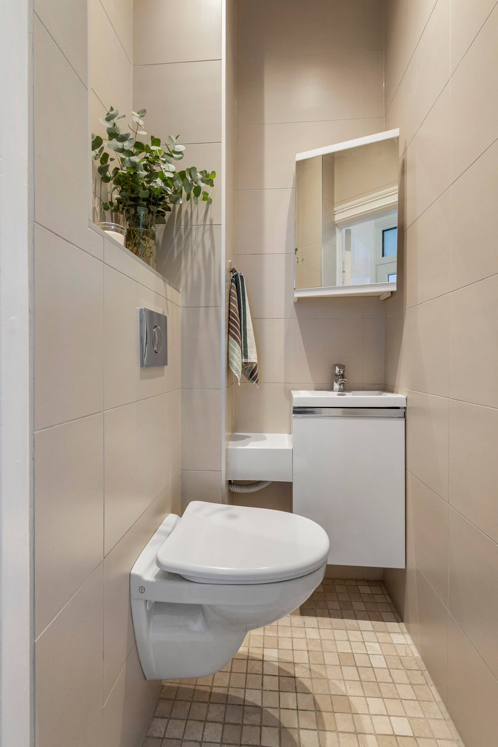 Fra entre er det adkomst til et separat toalettrom med servantskap med nedfelt servant, i tillegg til et speilskap over servanten. Galleribilde