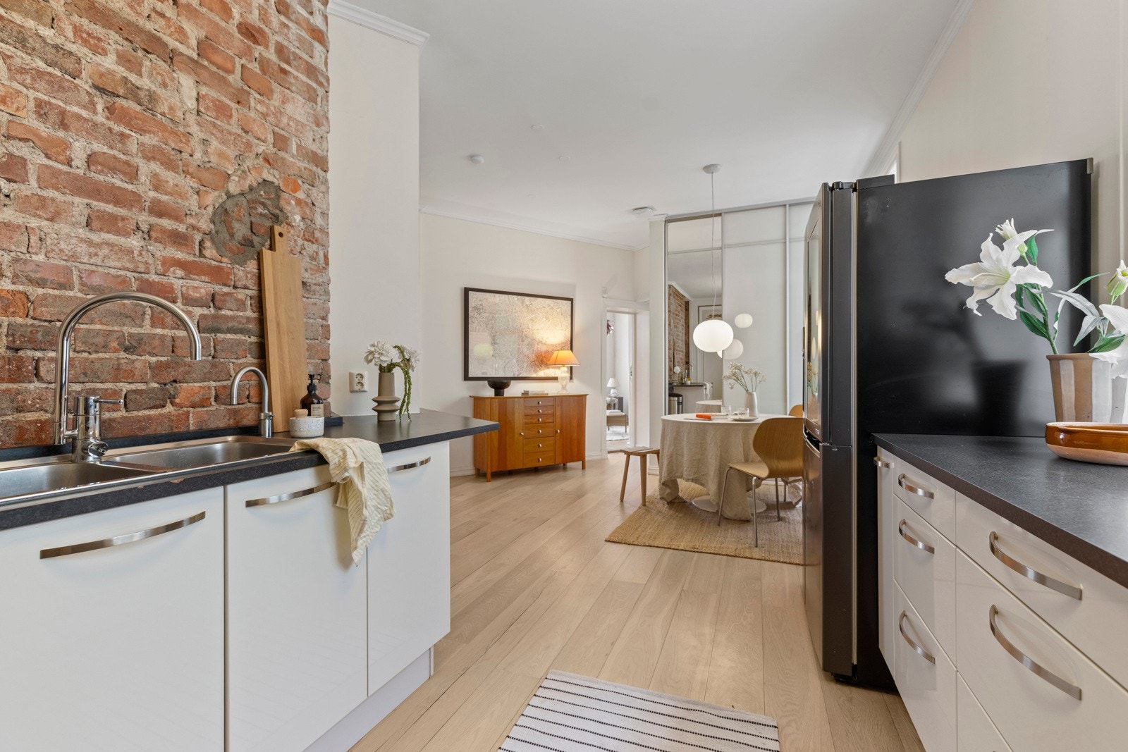 Kjøkkenet har store vindusflater og pene detaljer som teglsteinsvegg. Galleribilde