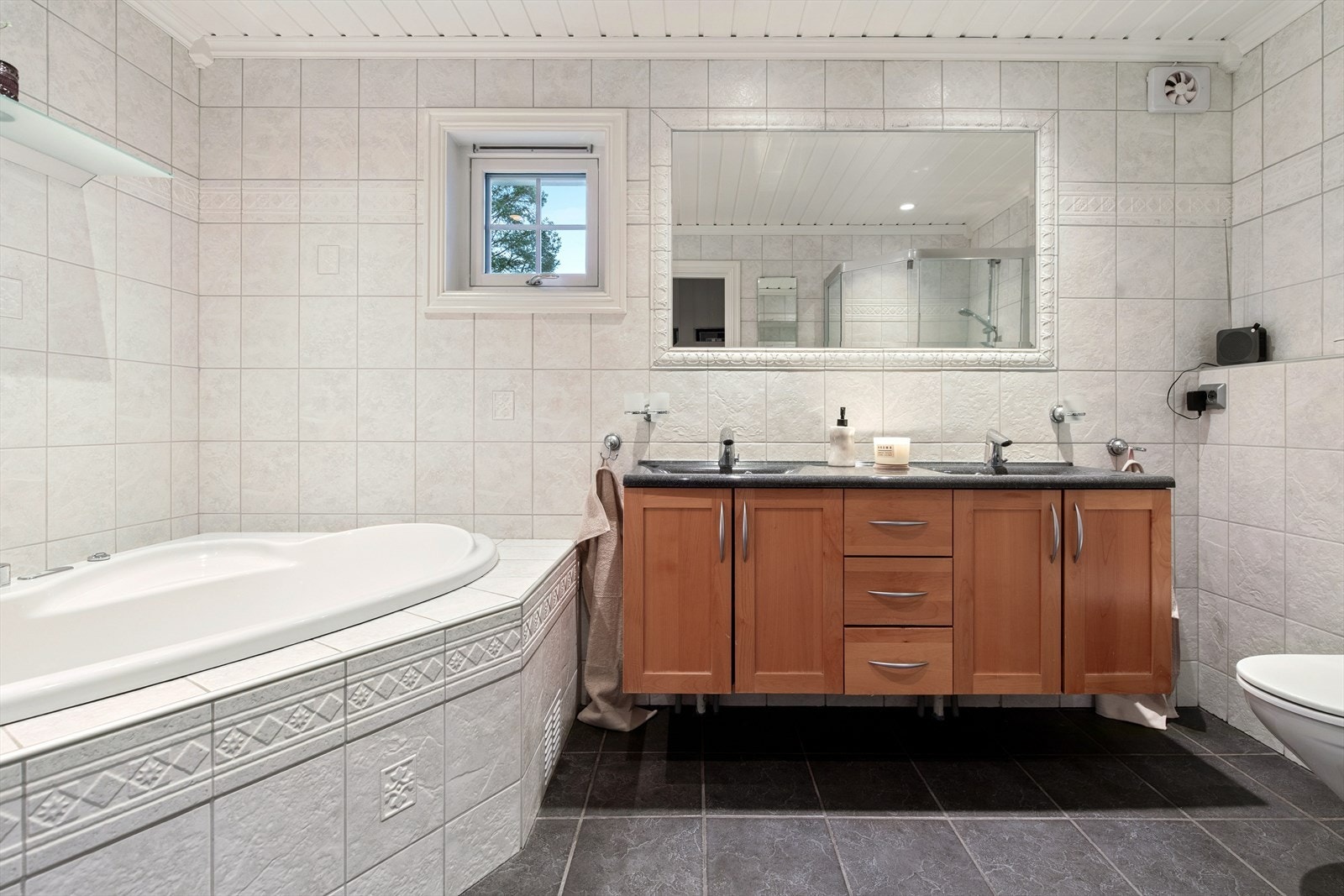 Her er det varmekabler i gulvet, servantinnredning og vegghengt toalett. Galleribilde