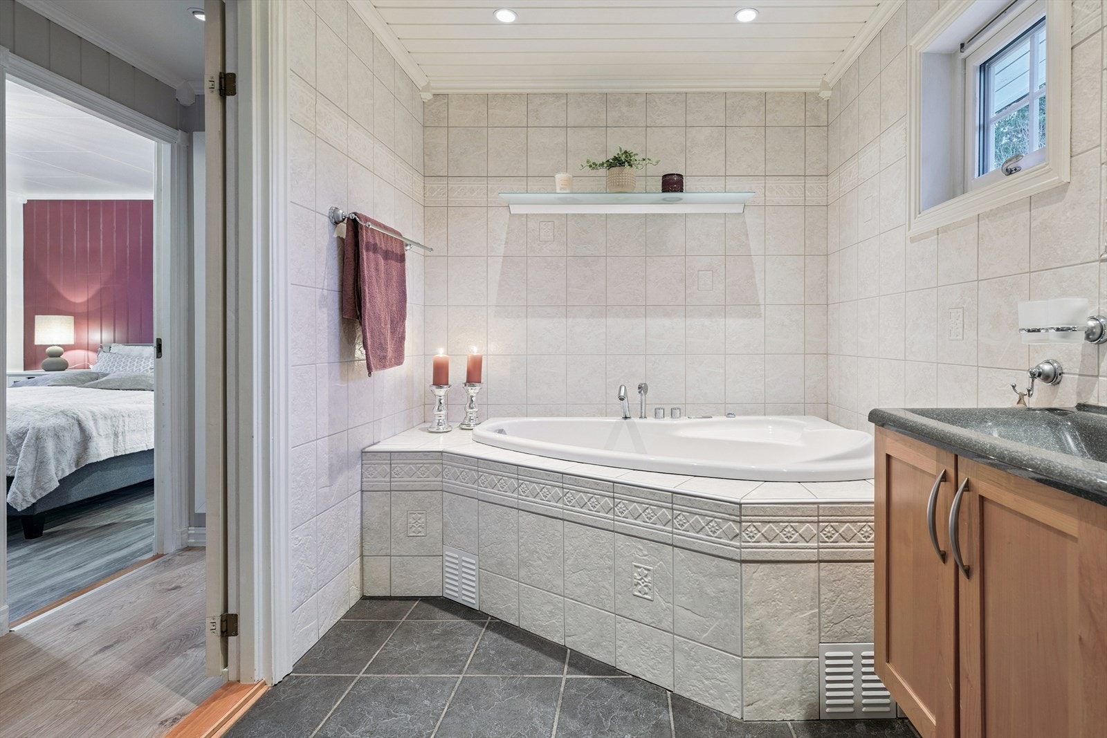 Hovedbadet er flislagt og utstyrt med både badekar og en åpen dusj. Galleribilde